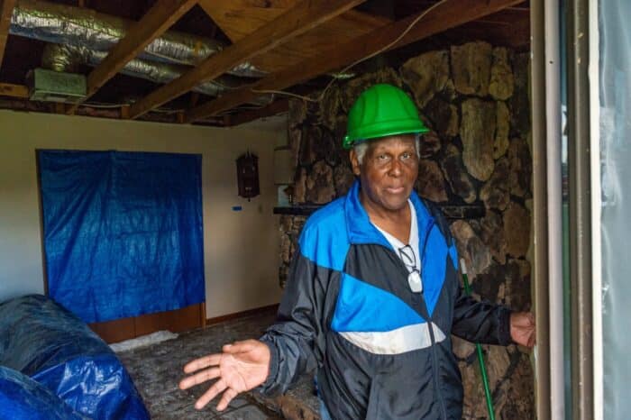 Nakatayo si Chester sa pintuan ng patio na kalaunan ay napako niya ang isang 2x4 sa kabuuan noong Hurricane Ida.