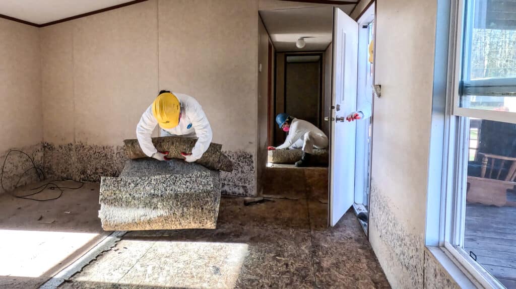 team removes debris from a hurricane-damaged home