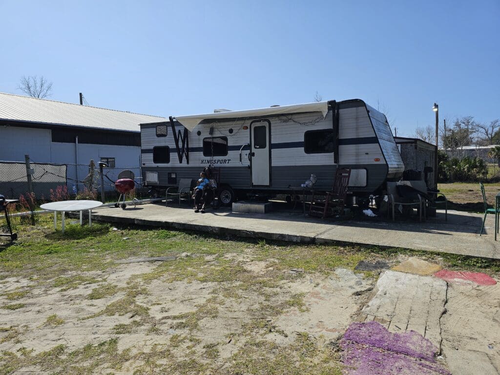 Hurricane Michael survivors sitting in front of their RV trailier