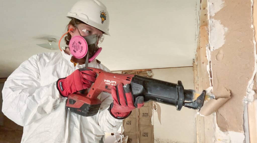 AmeriCorps member gutting a home destroyed during a hurricane