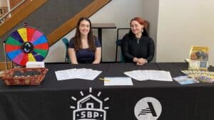 two people sitting at a table filled with pamphlets and flyers about disaster preparedness