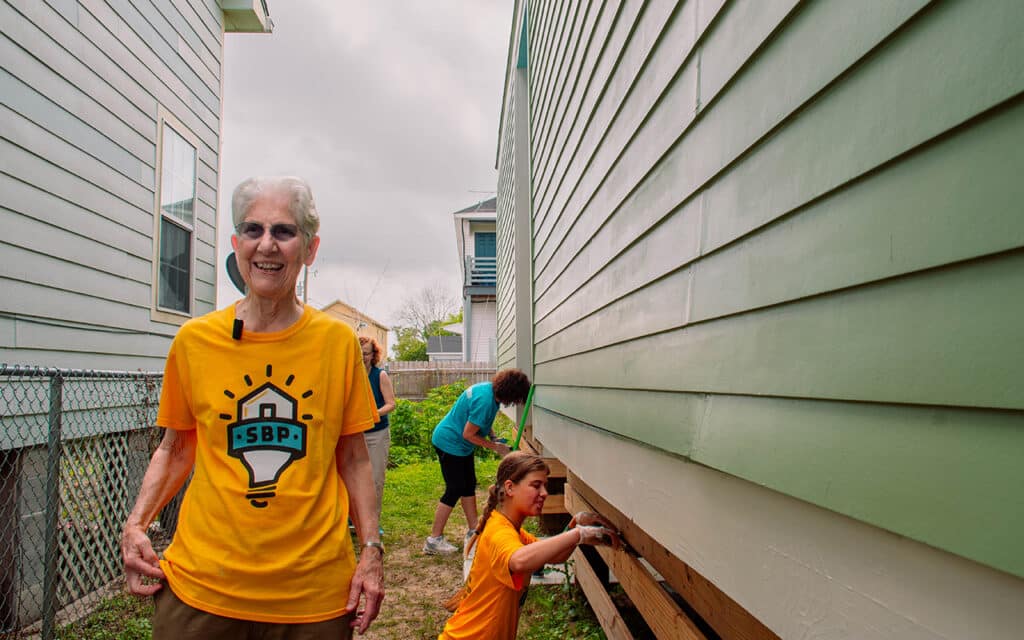 Sister Regina Marie stands in front of house being rebuilt