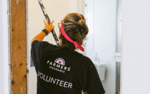 a volunteer paints the inside of a home damaged during a hurricane